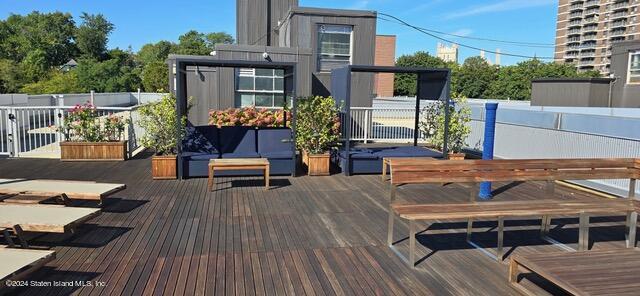 a view of a patio with table and chairs potted plants with wooden floor and fence