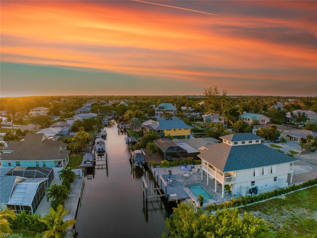 an aerial view of residential houses with outdoor space and ocean