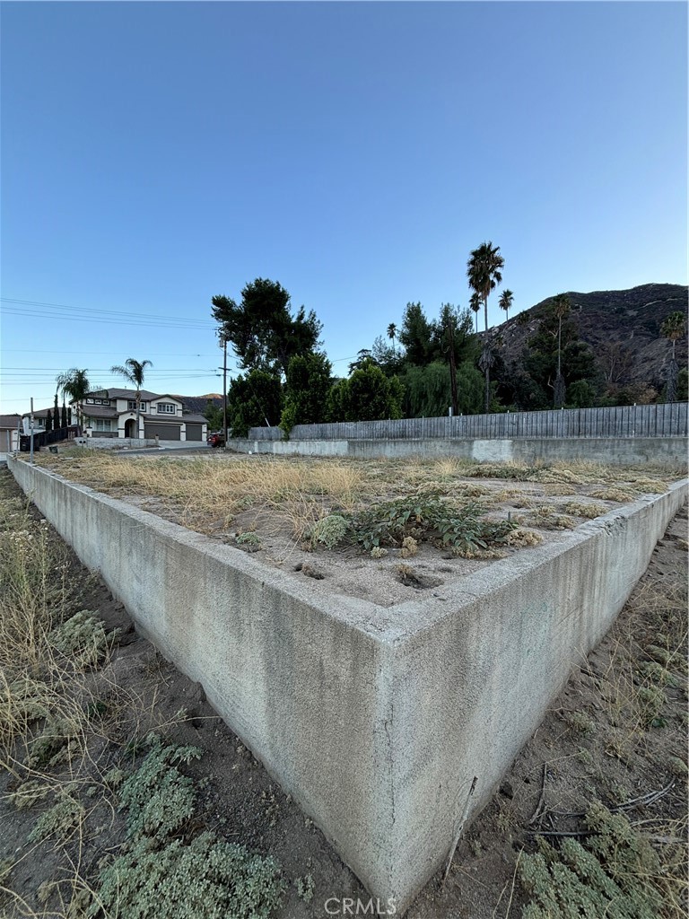 a view of a dry yard with wooden fence