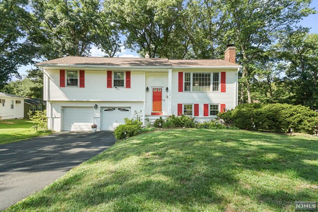 a front view of a house with a garden and yard