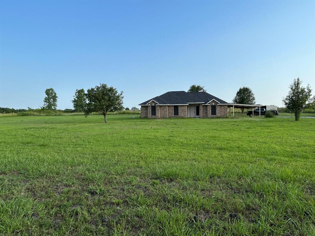 a view of a house with a yard and sitting area