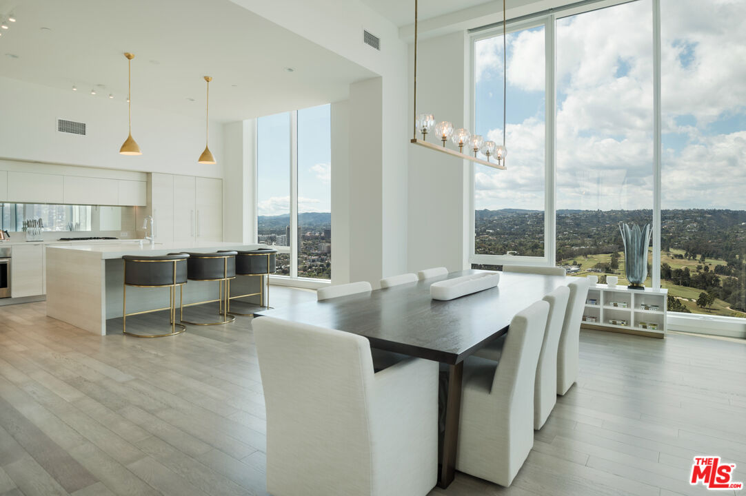 a living room with couches chairs and view of kitchen appliances