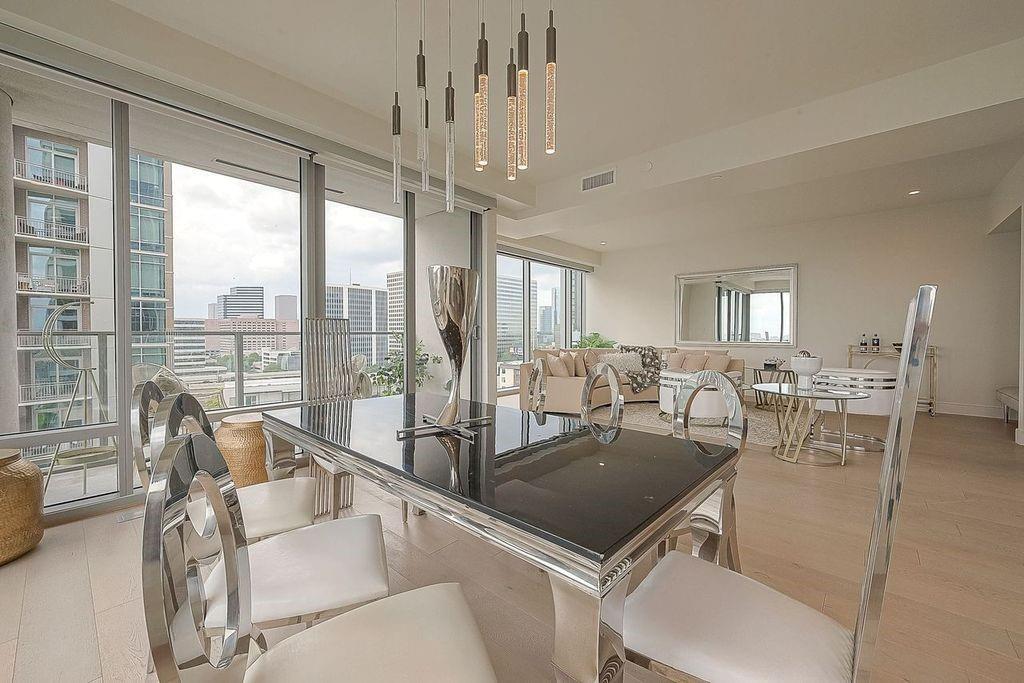 a view of a dining room and livingroom with furniture wooden floor a chandelier