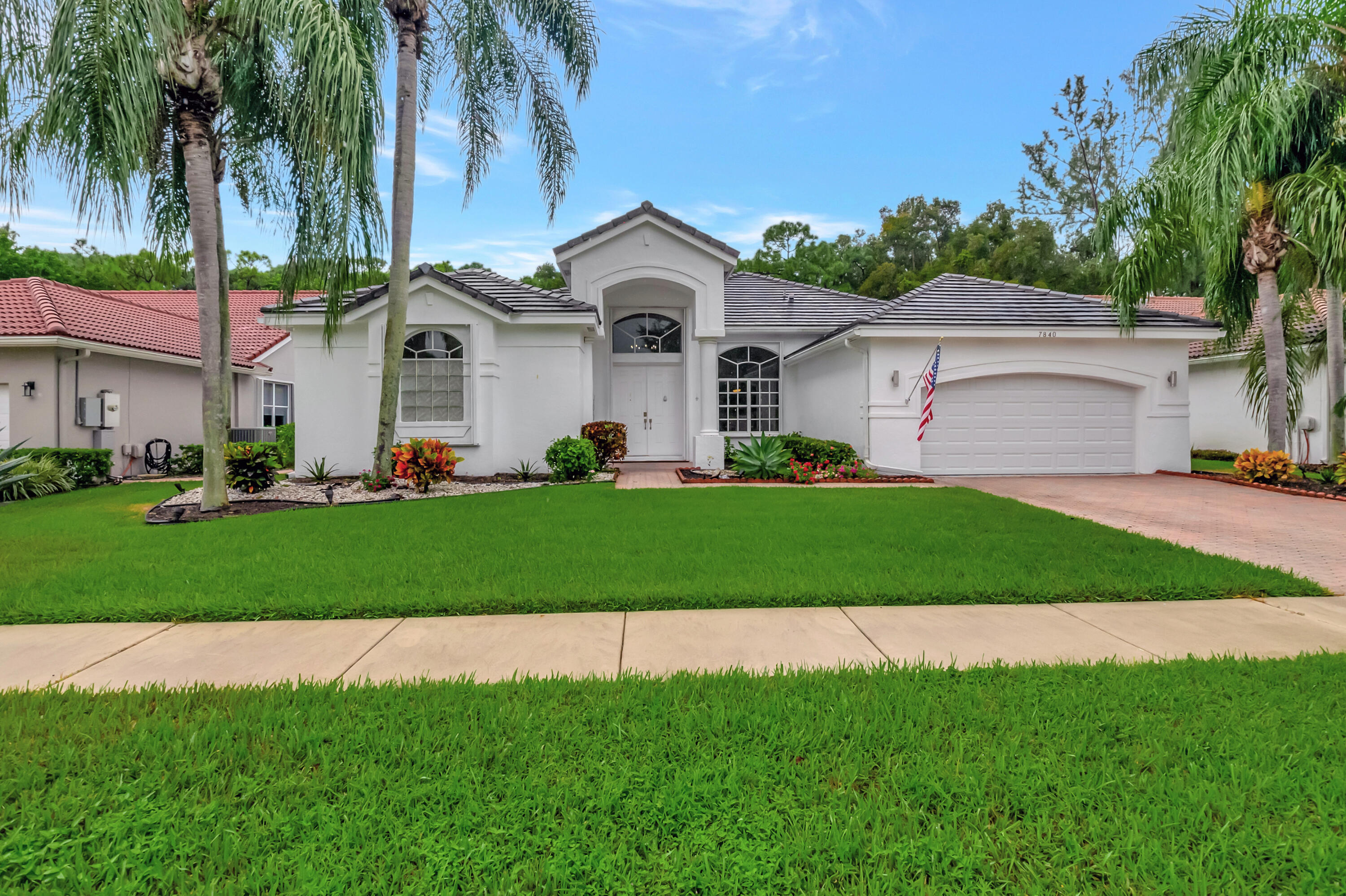 a front view of a house with a garden and yard