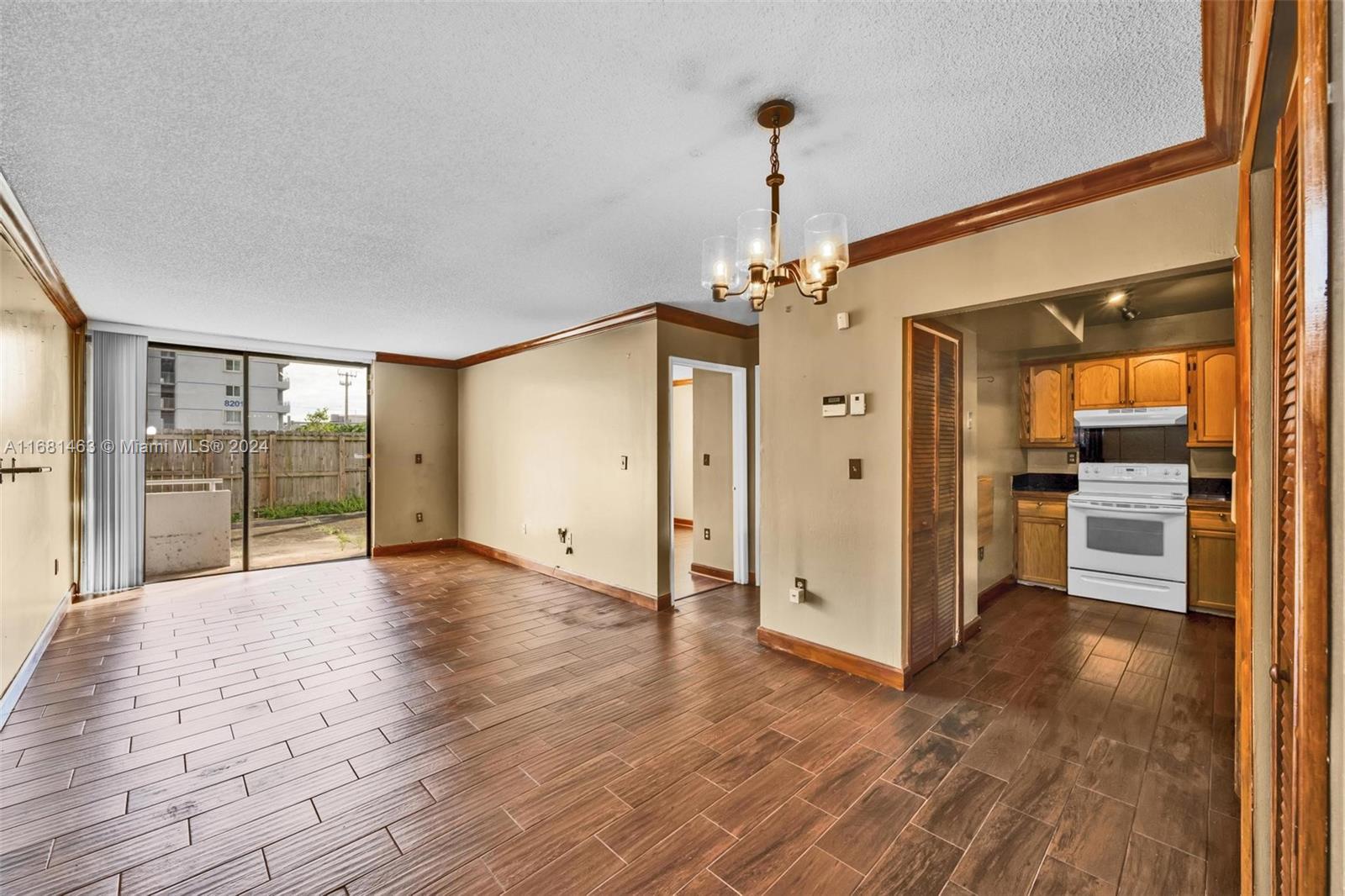 a view of empty room with wooden floor and windows