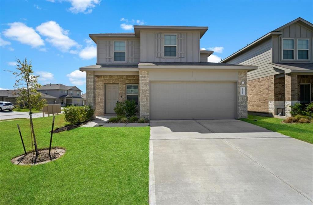 a front view of a house with a yard and garage