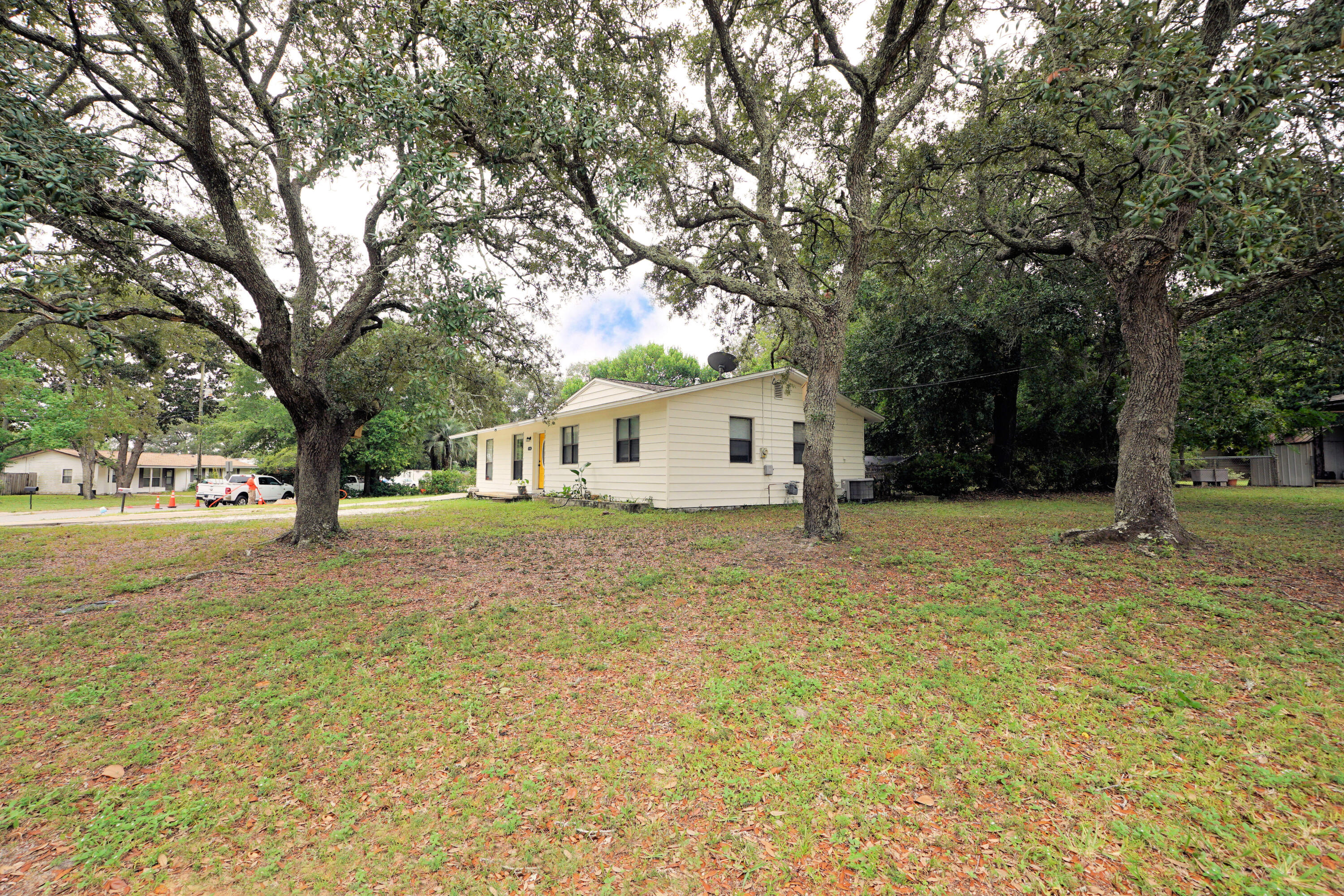 a front view of a house with a yard and trees