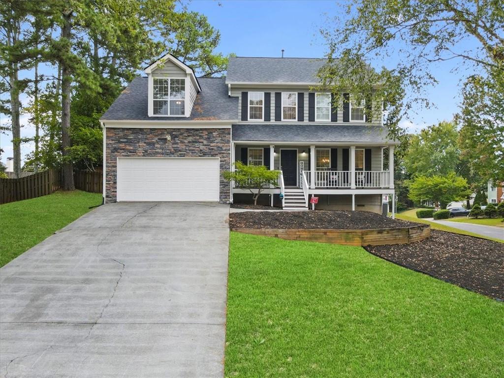 a front view of a house with yard and green space