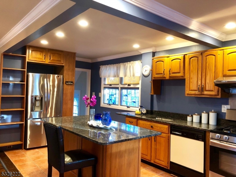 a kitchen with stainless steel appliances granite countertop a sink and wooden cabinets