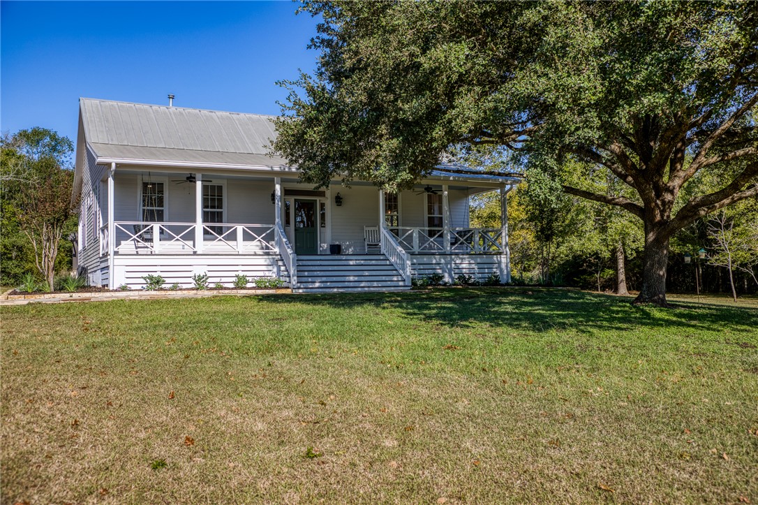 View of front facade featuring a porch, a front la