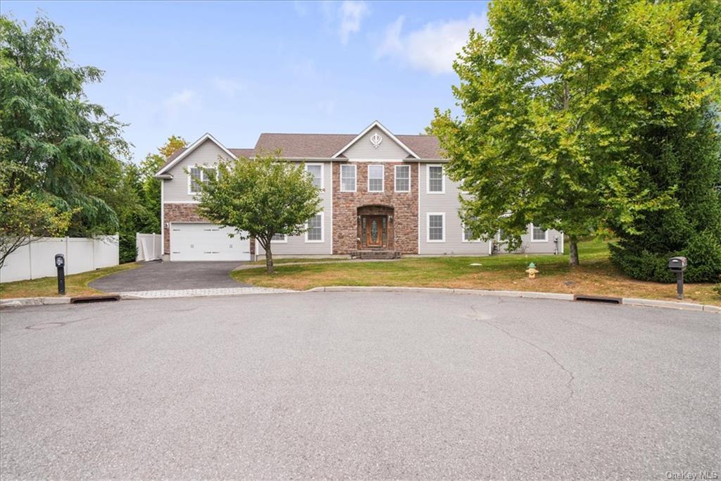 View of front of house with a front yard and a garage