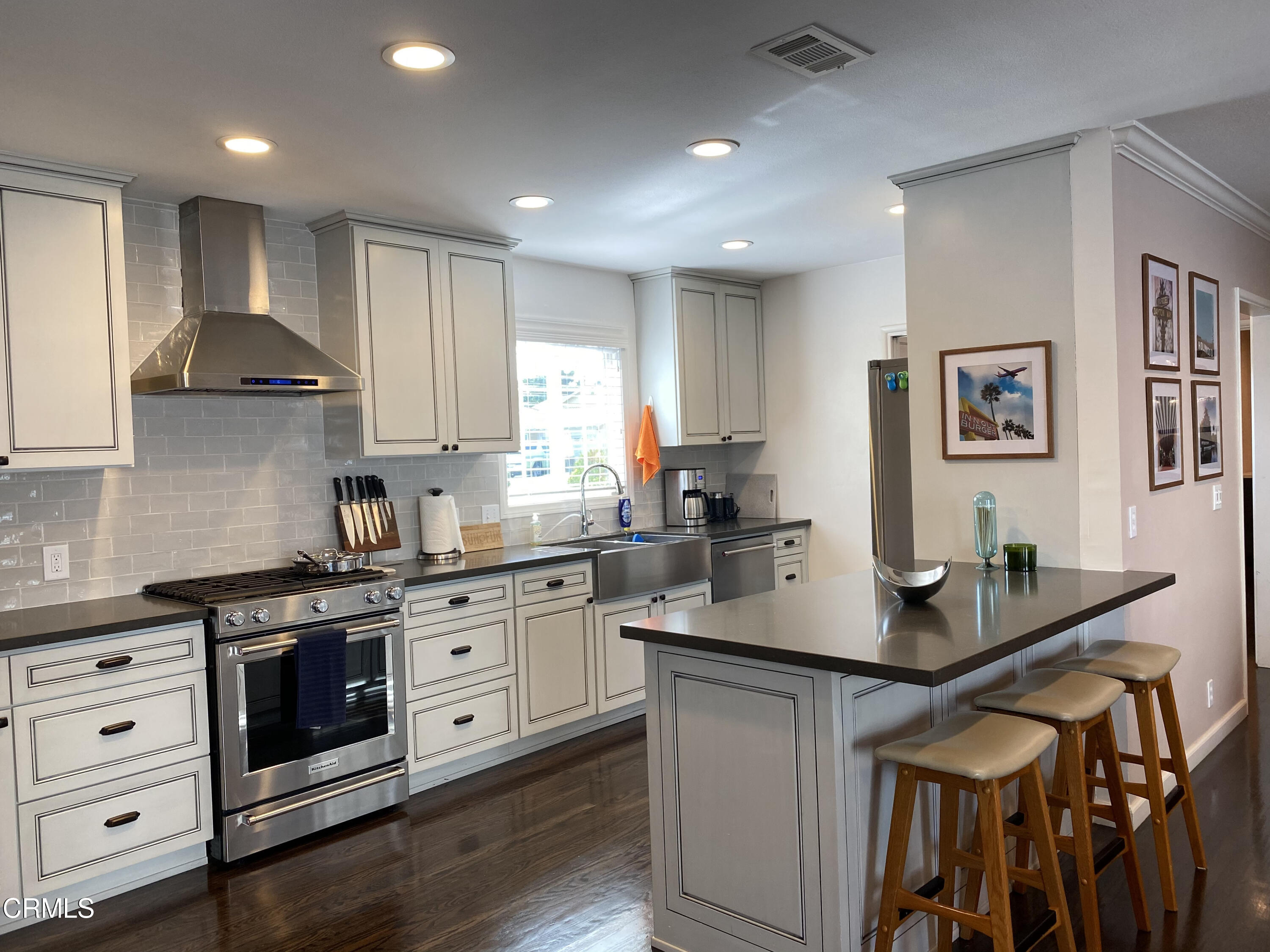 a kitchen with stainless steel appliances granite countertop a stove a sink and a refrigerator