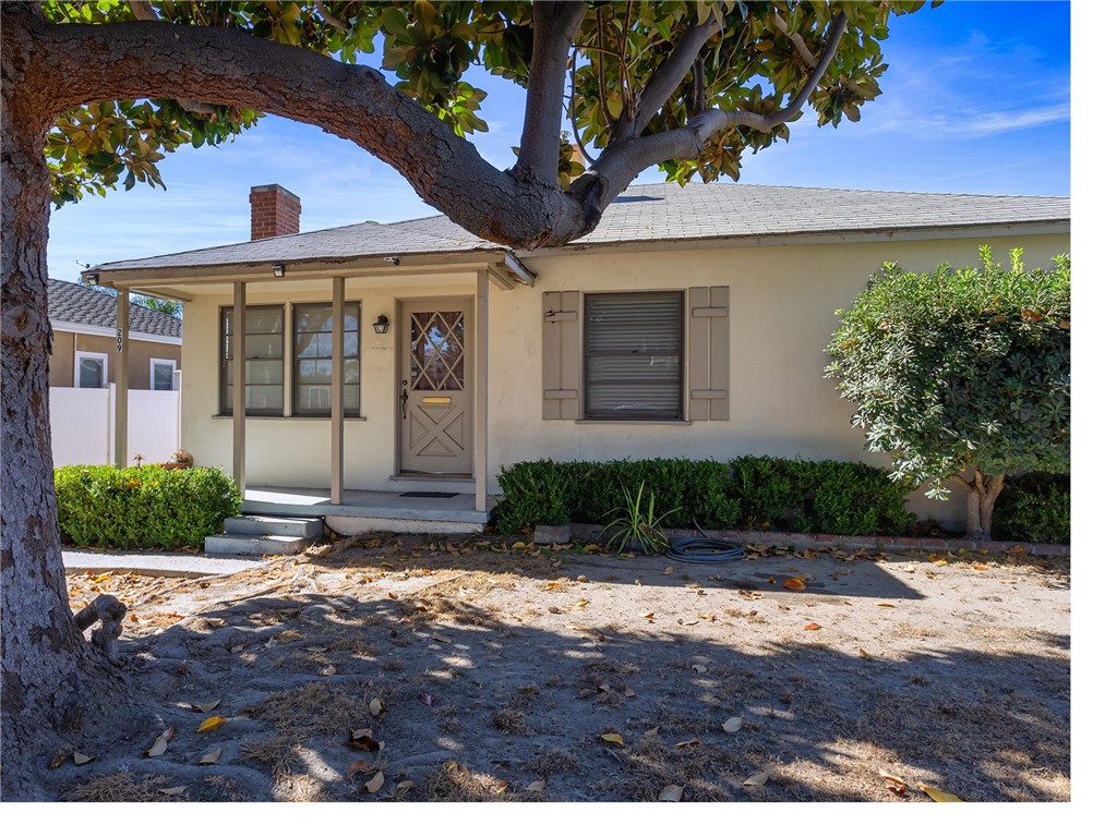 a front view of a house with a yard and potted plants