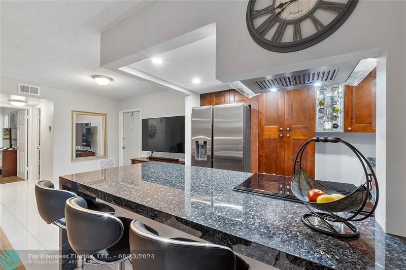 a kitchen with stainless steel appliances granite countertop a sink a stove and a dining table