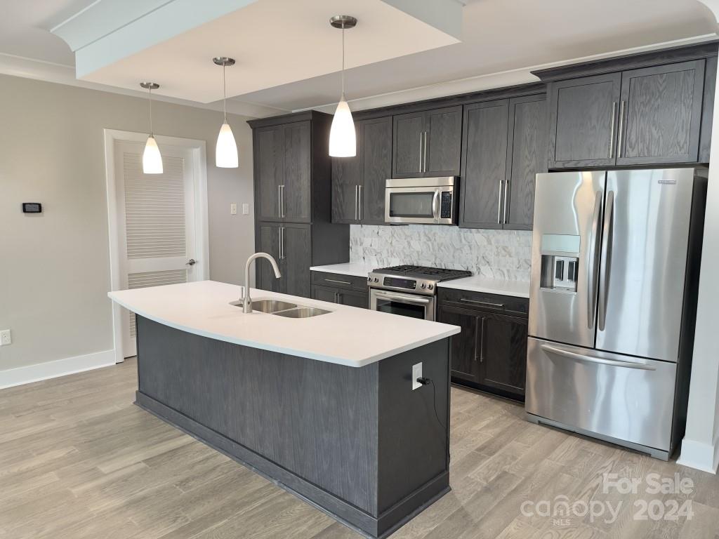 a kitchen with kitchen island a sink stainless steel appliances and refrigerator