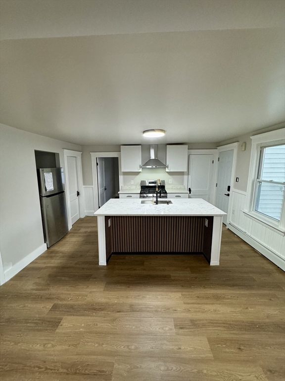 a living room with furniture a mirror and a wooden floor