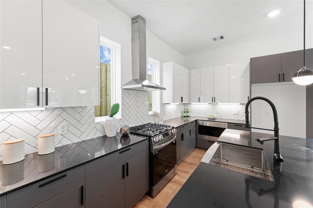 a kitchen with granite countertop a sink stainless steel appliances and cabinets