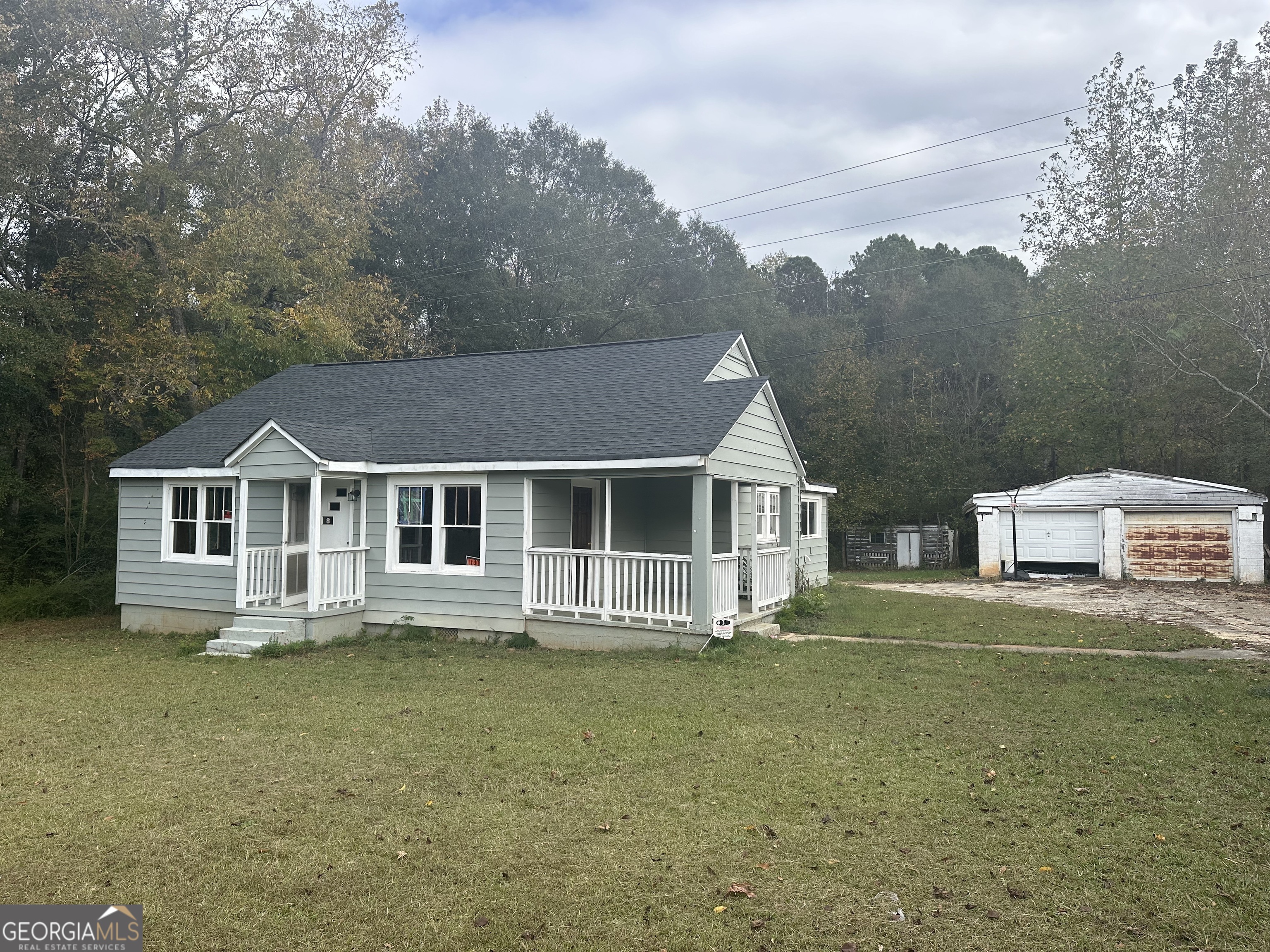 a front view of a house with a yard and trees