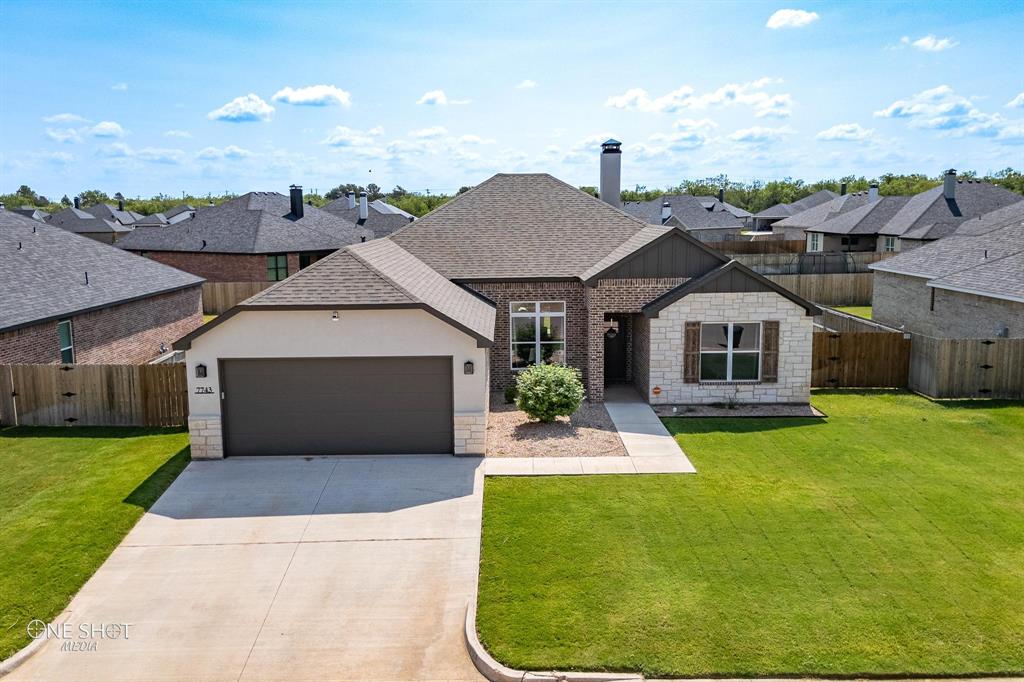 a aerial view of a house with a yard and garage