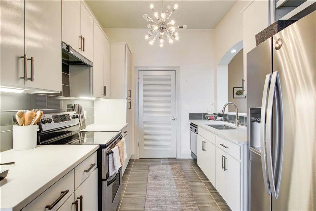 a kitchen with stainless steel appliances a sink stove and refrigerator