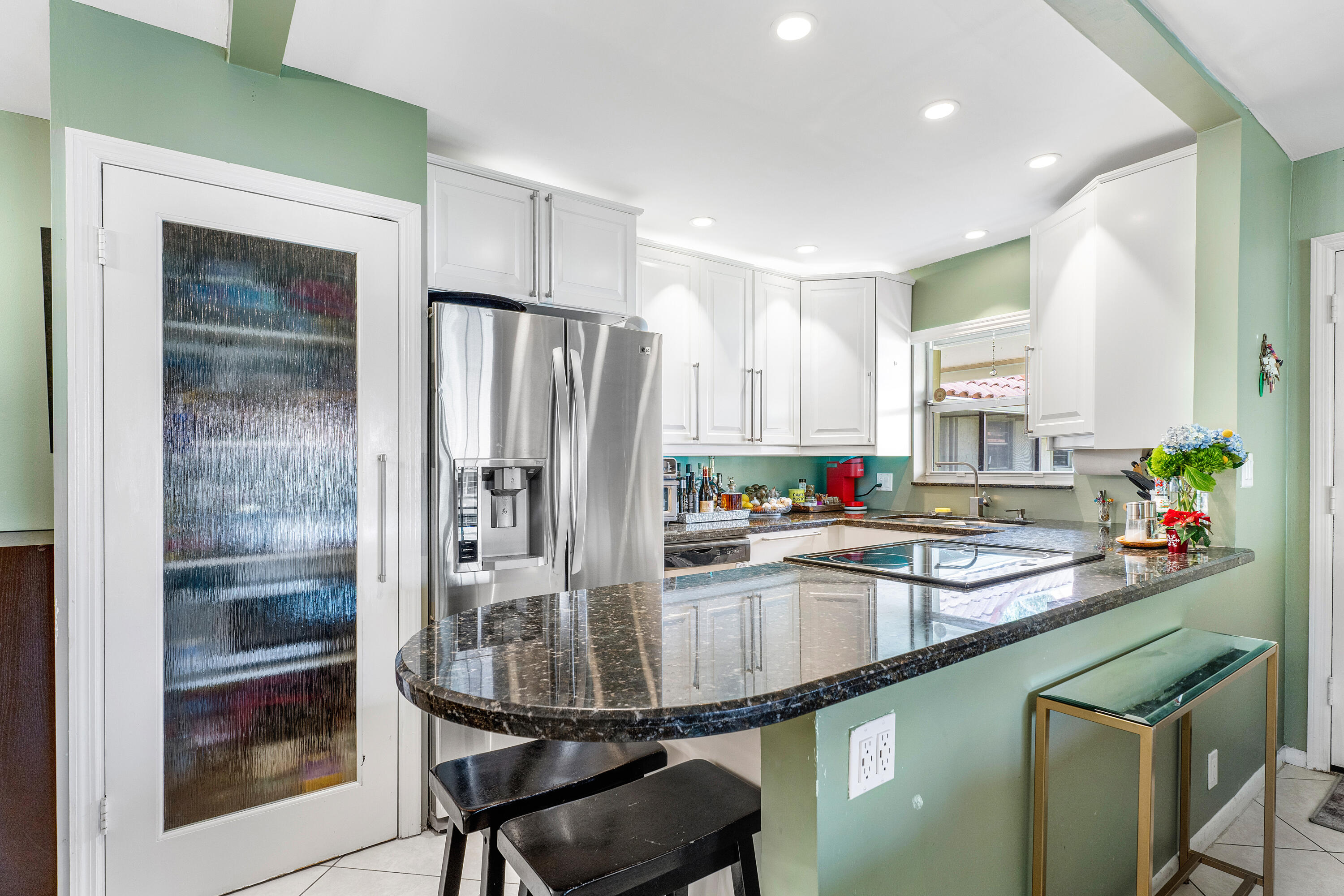 a kitchen with stainless steel appliances granite countertop a sink and a refrigerator