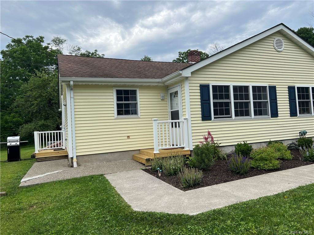 a view of a house with backyard and a garden