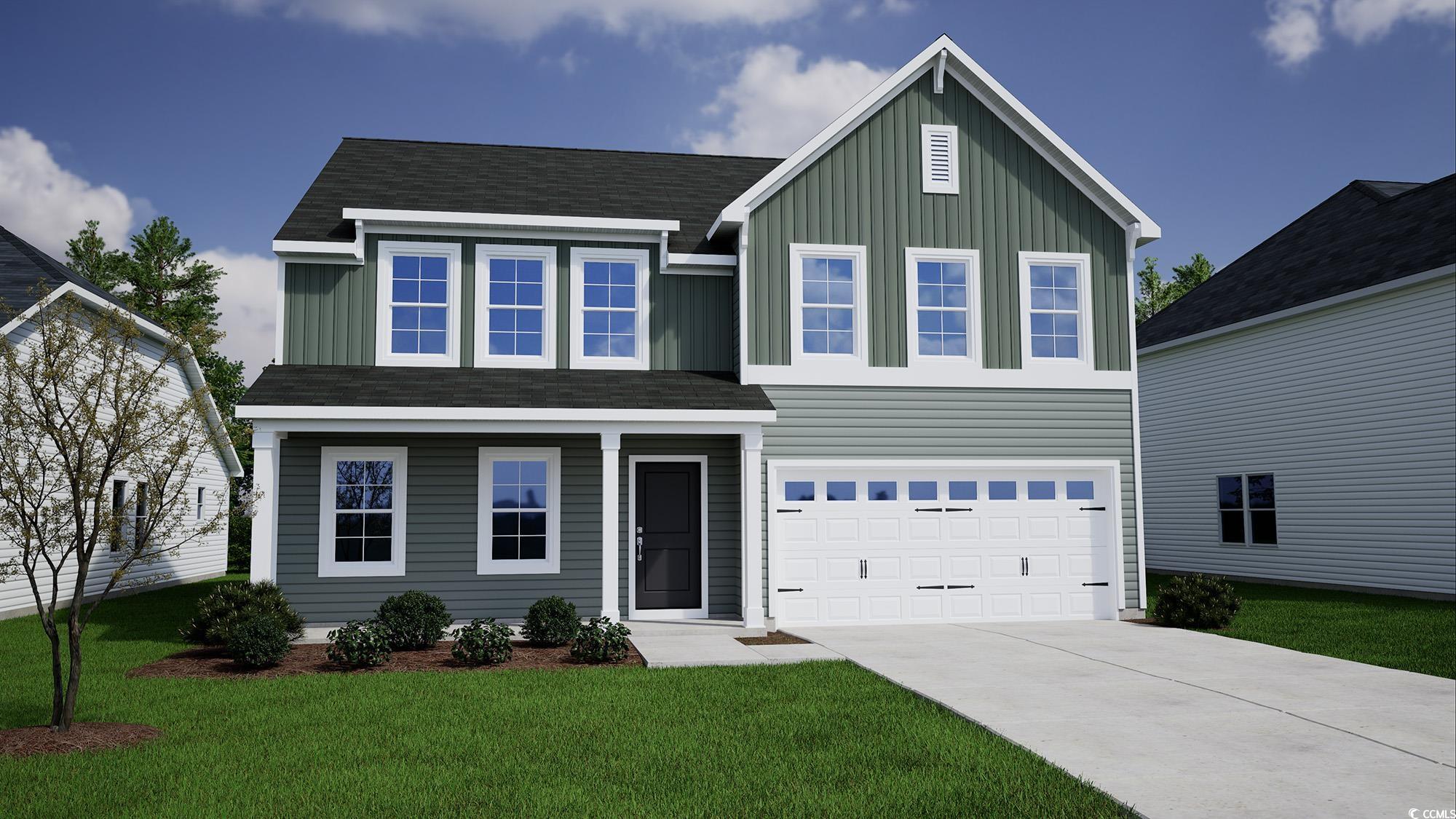 View of front of home with a front lawn and a gara