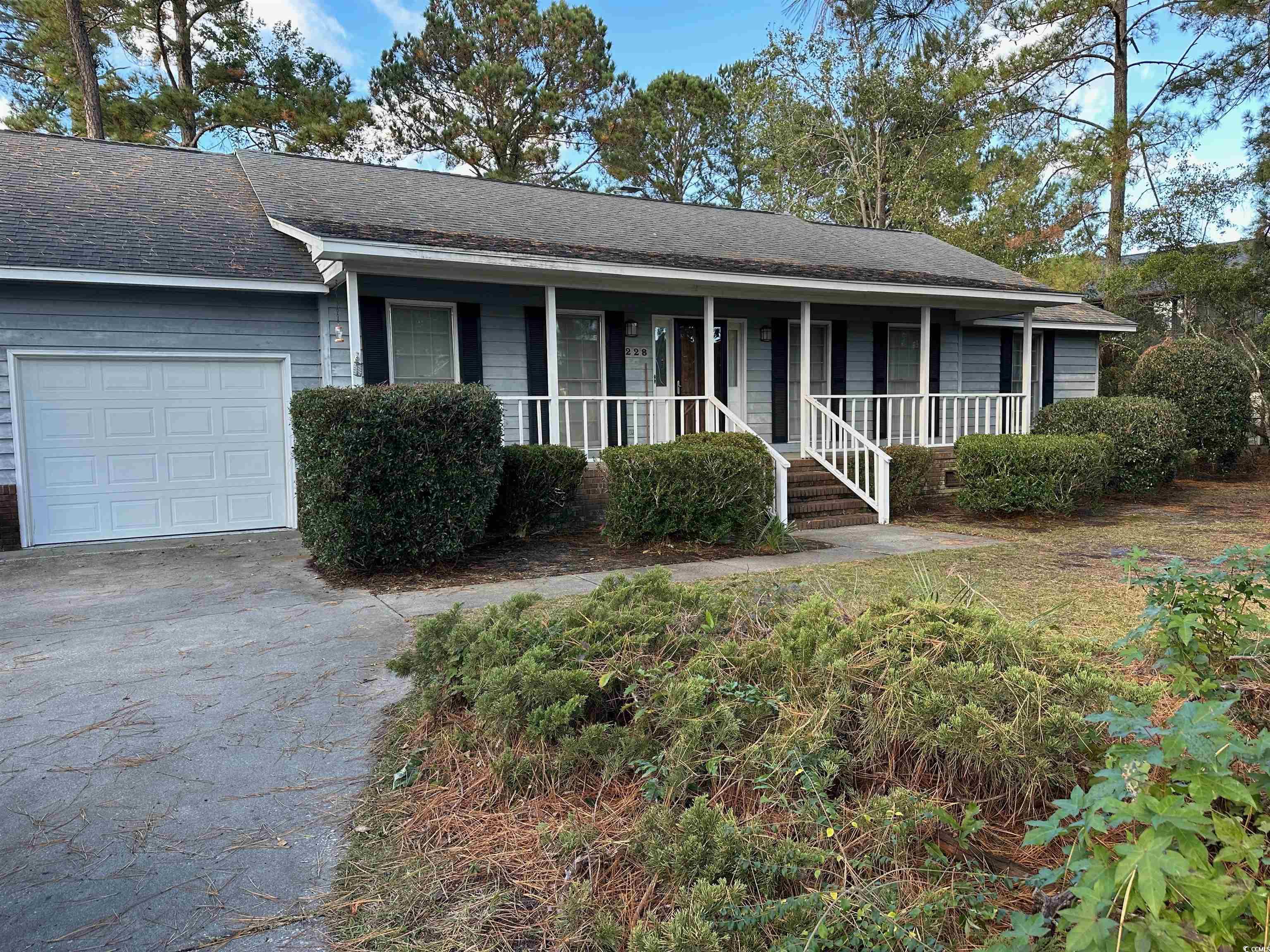 Single story home featuring covered porch and a ga