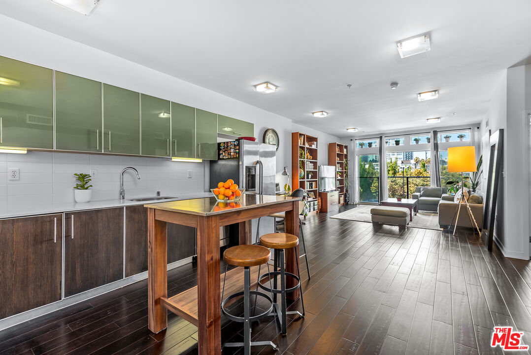 a view of kitchen with stainless steel appliances dining table and chairs