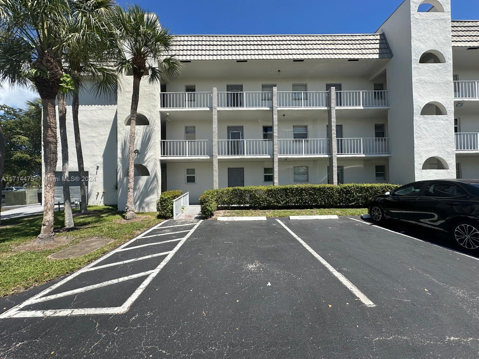 View of the apartment from outside with its parking space in front