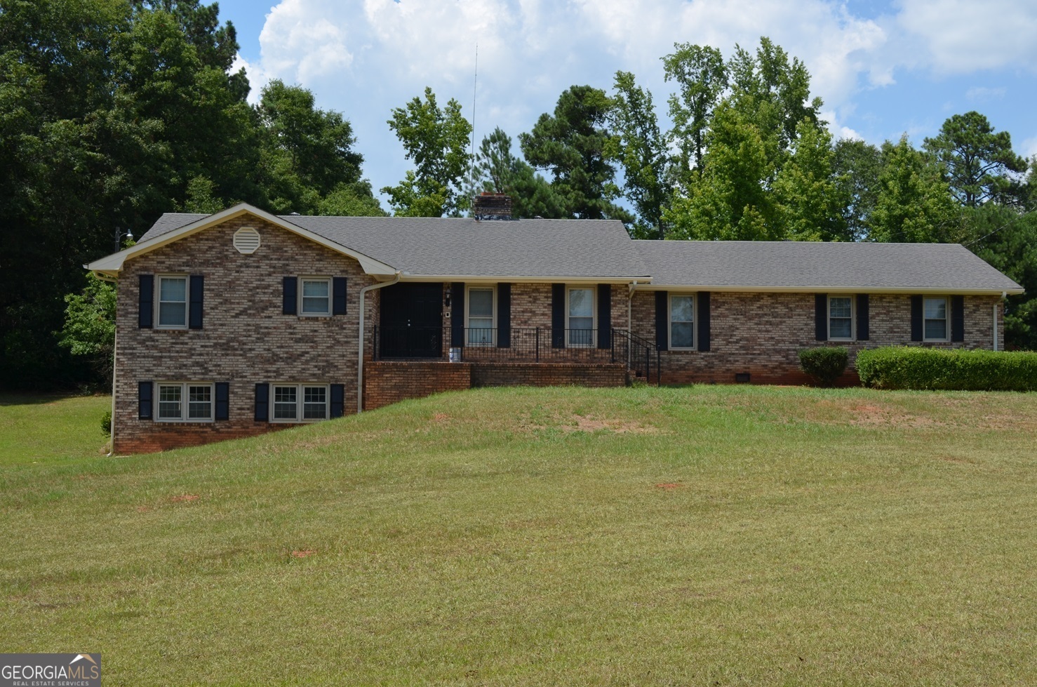 a front view of a house with a garden