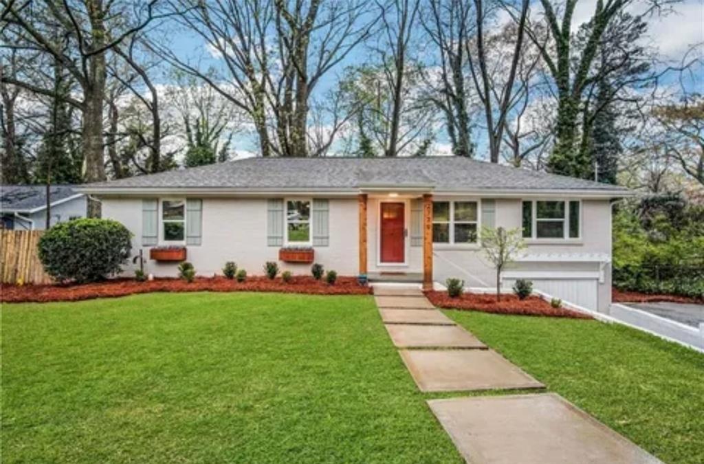 a front view of a house with a yard and trees