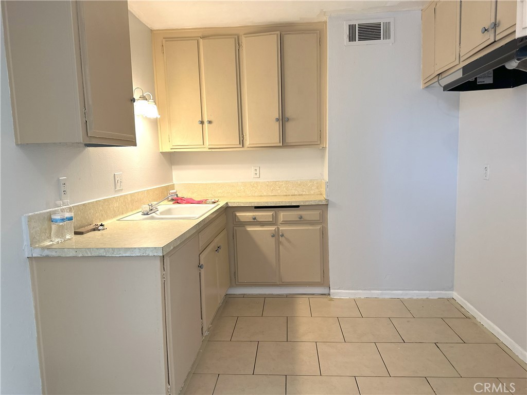 a utility room with a sink a cabinetry and a stove