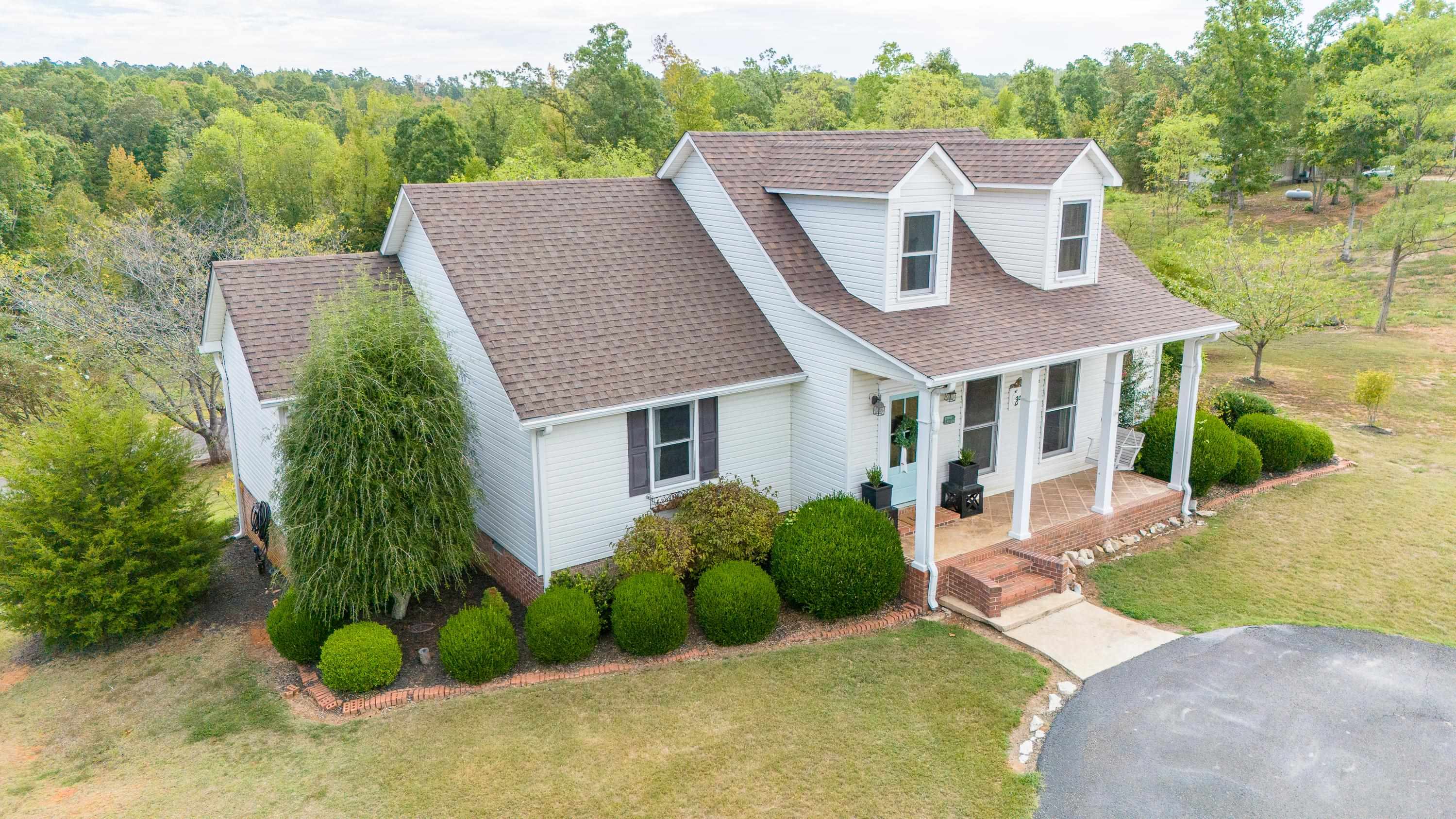 Cape cod home with a front lawn and covered porch