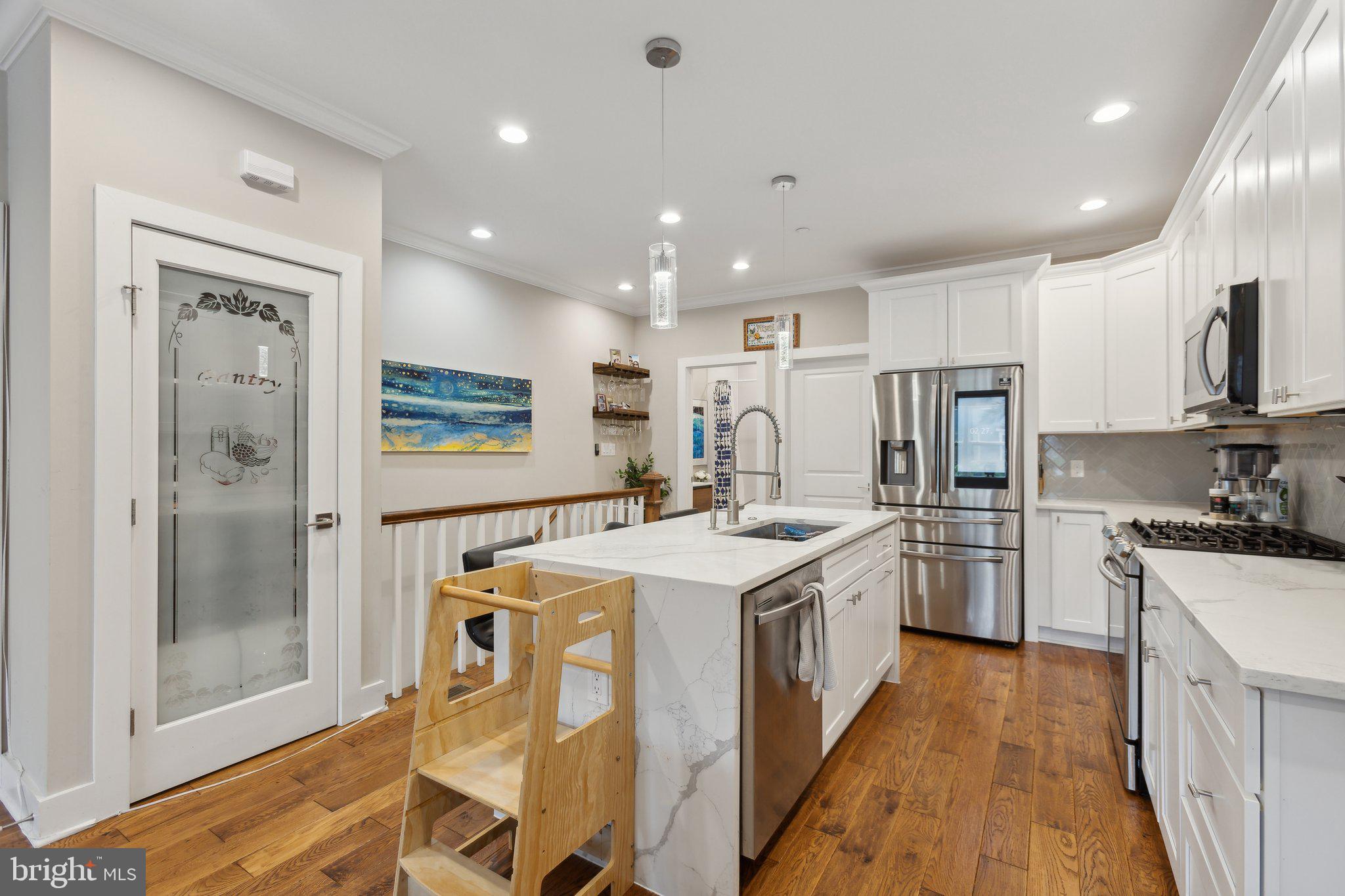 a kitchen with refrigerator a sink and white cabinets