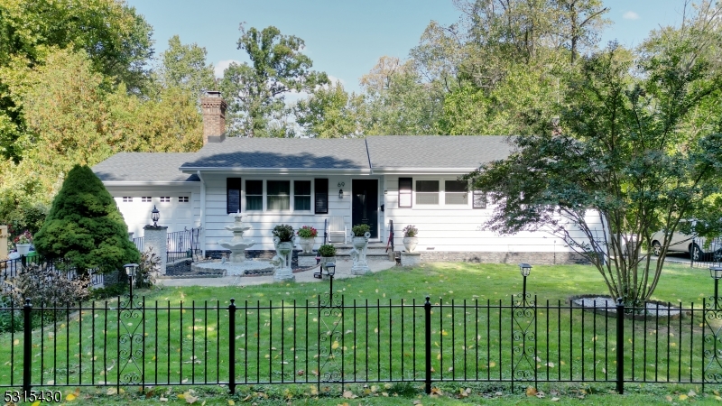 a front view of a house with a garden and trees