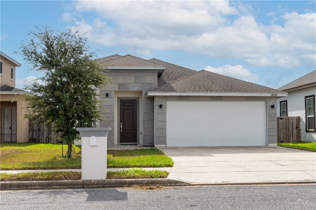 View of front facade with a garage and a front lawn