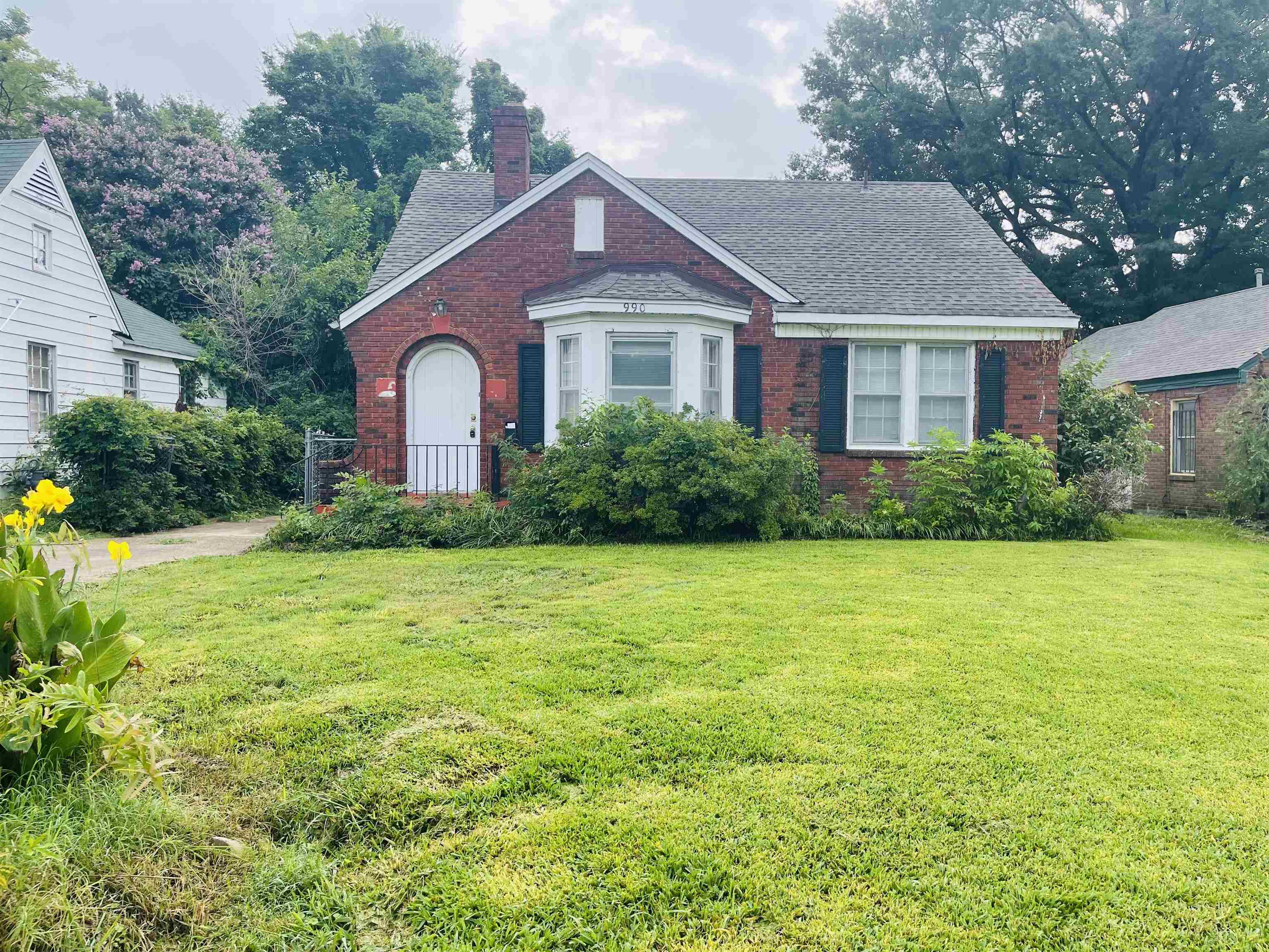 a front view of a house with a yard and trees