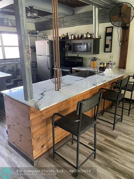 a kitchen with stainless steel appliances kitchen island granite countertop a table and chairs in it