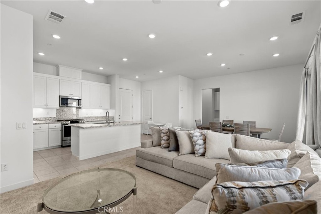 a living room with furniture and kitchen view