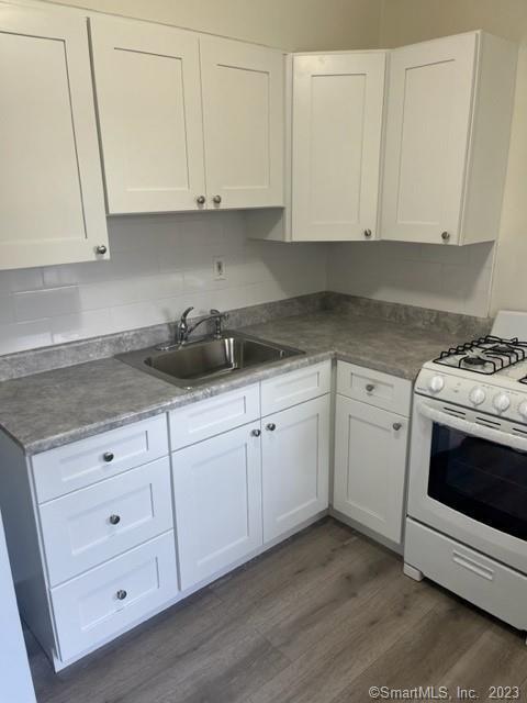 a kitchen with white cabinets and white appliances