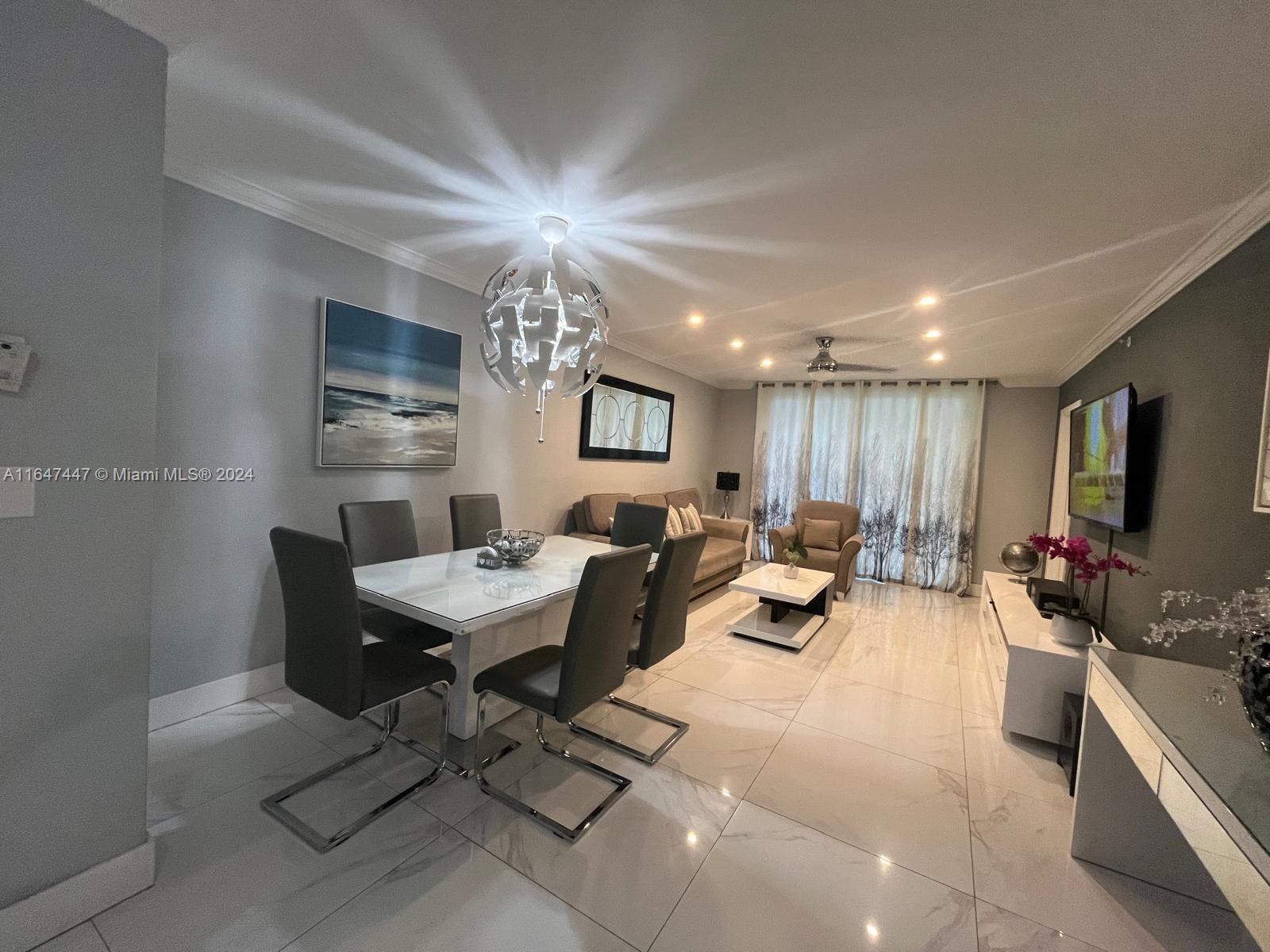 a living room with furniture kitchen view and a window