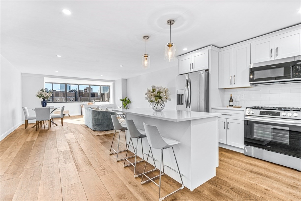 a kitchen with stainless steel appliances kitchen island granite countertop a stove a sink and a refrigerator