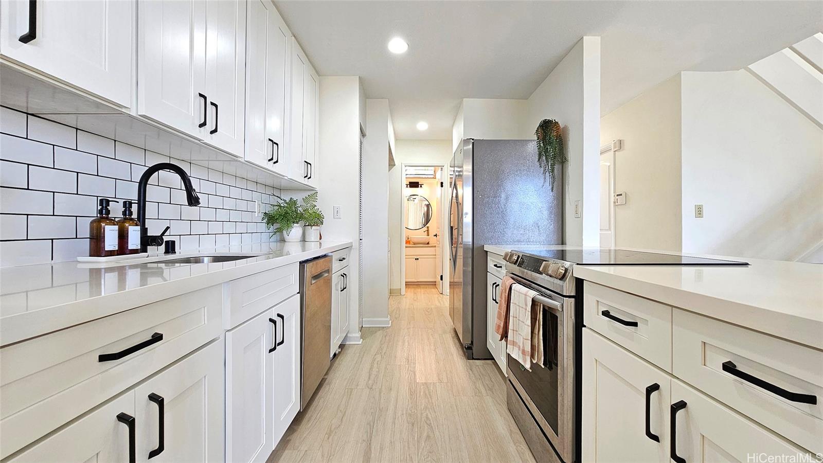 a kitchen with stainless steel appliances a sink and a refrigerator