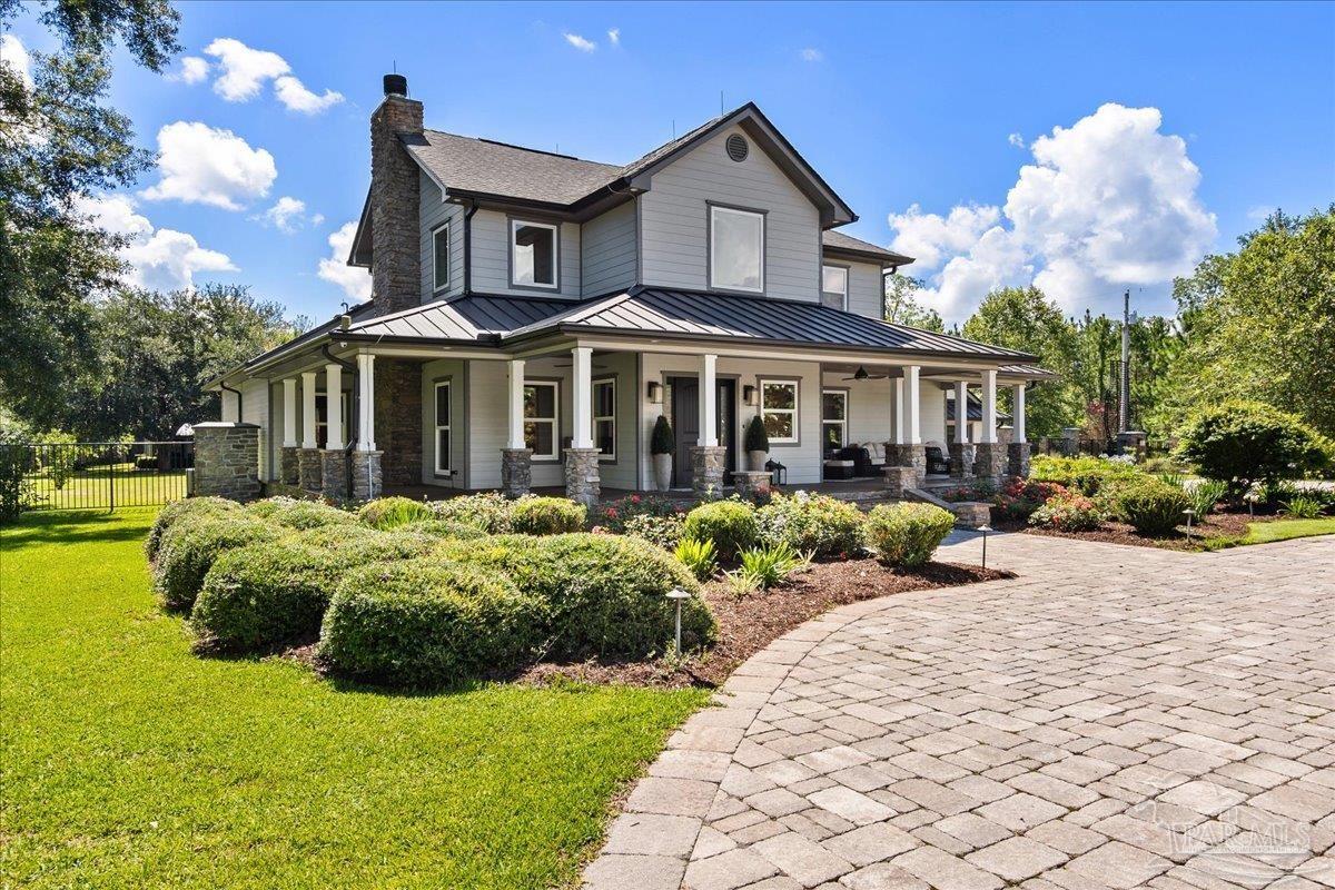 a front view of a house with a yard and potted plants