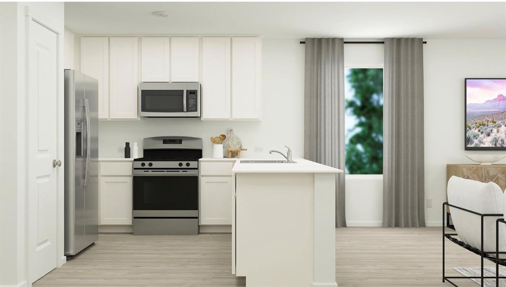 a kitchen with stainless steel appliances a stove microwave and refrigerator