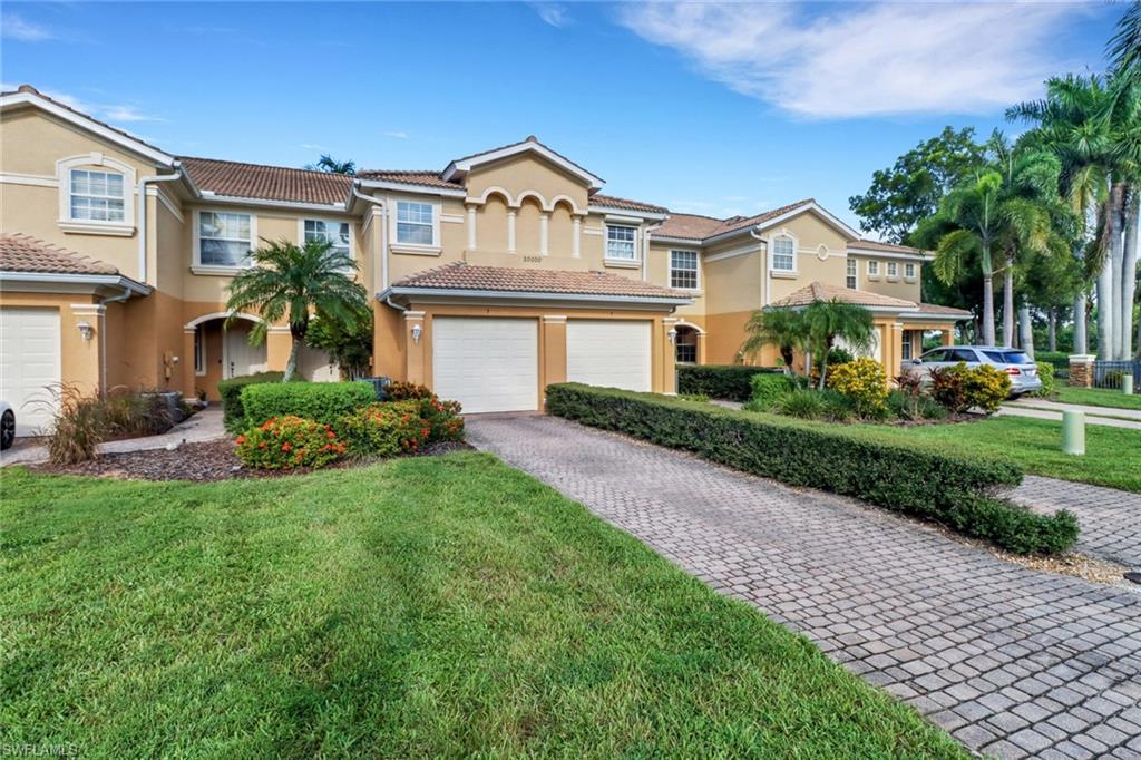 View of property featuring a front yard and a garage