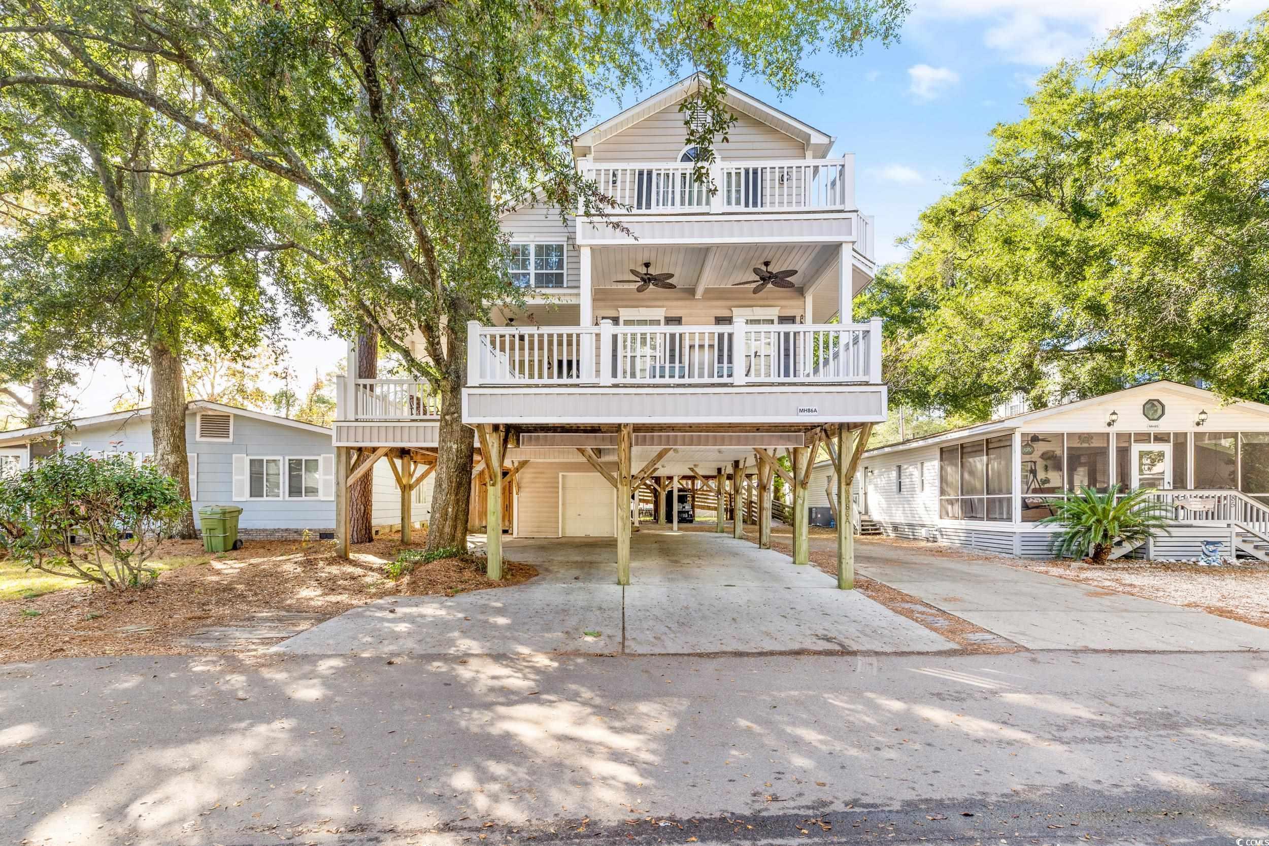 Beach home featuring a balcony, ceiling fan, a sun