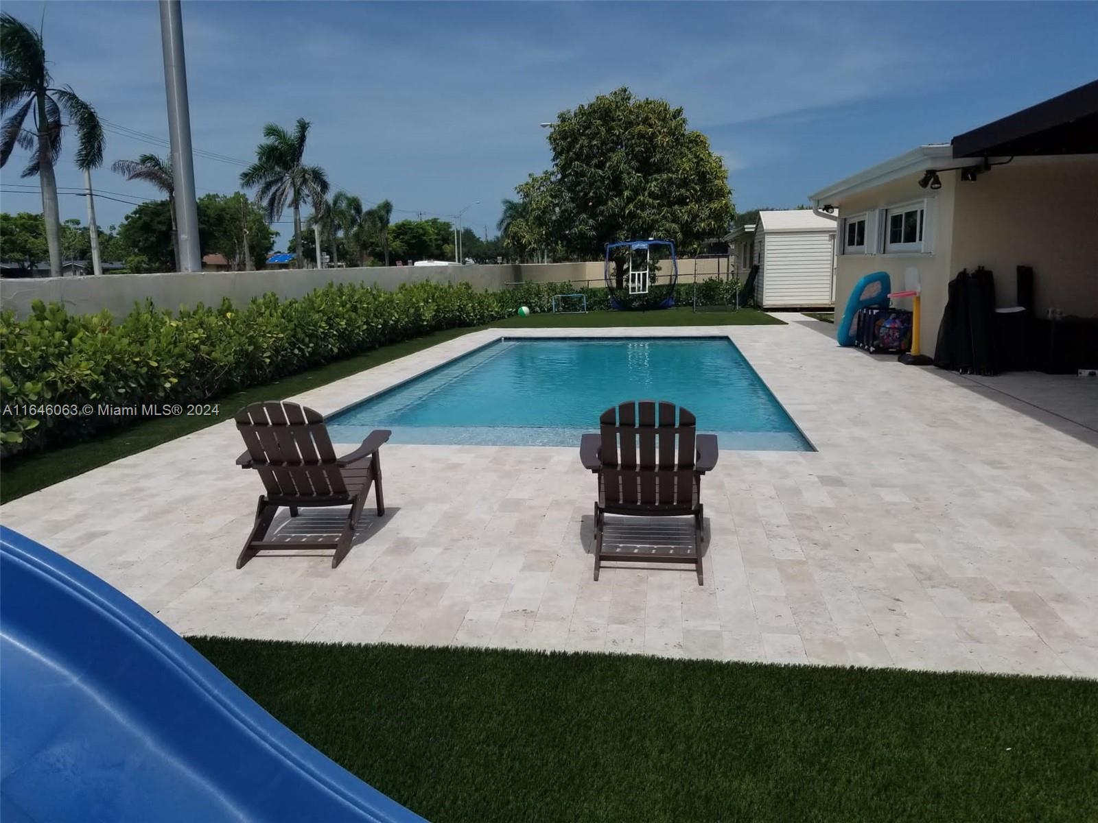 a swimming pool with outdoor seating and garden