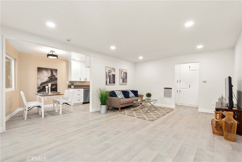 a living room with furniture a flat screen tv and a large window